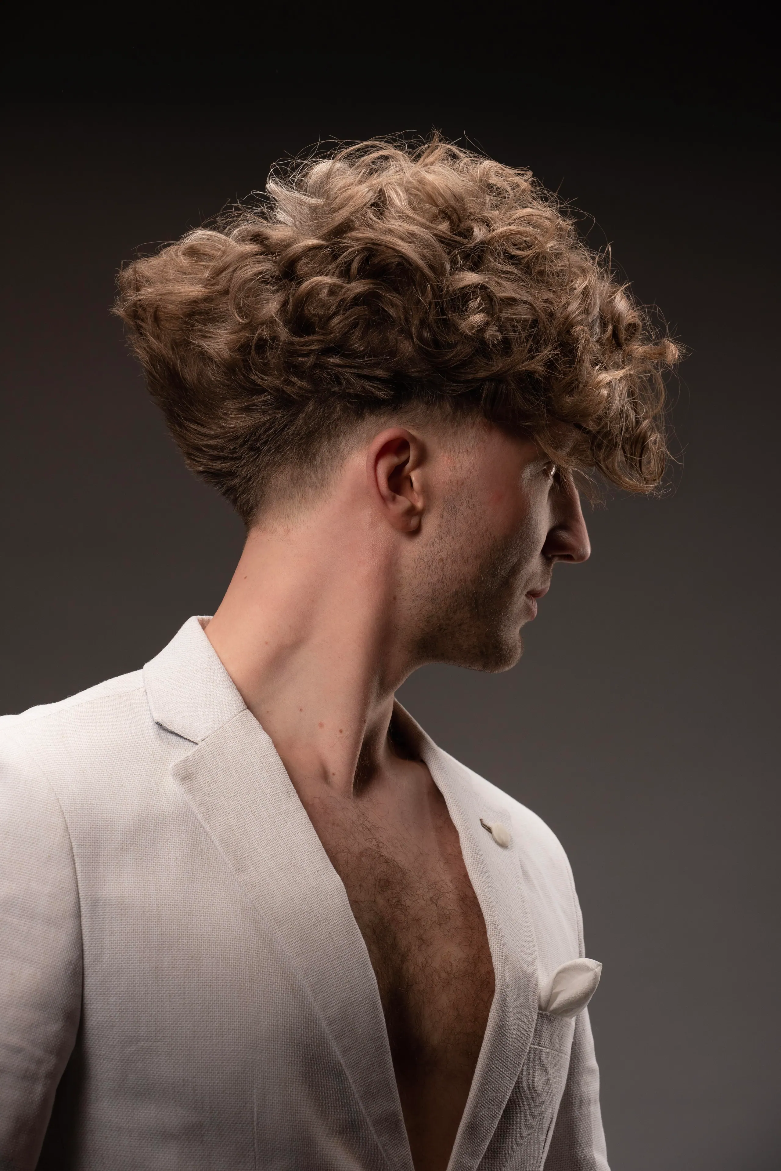 Skin fade i profil med lockig topp – herrklippning hos CUTS&CUPS Varberg